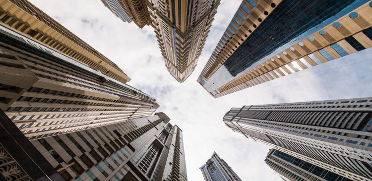 Widok z dołu na nowoczesne wieżowce w Dubaju, symbol dynamicznego rynku nieruchomości i skalowania inwestycji kapitałowych.