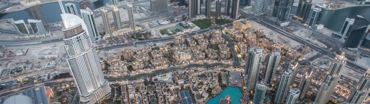 Panorama centrum Dubaju z lotu ptaka, gęsta zabudowa wieżowców, kanały wodne i nowoczesna infrastruktura miejska widziane o zmierzchu.