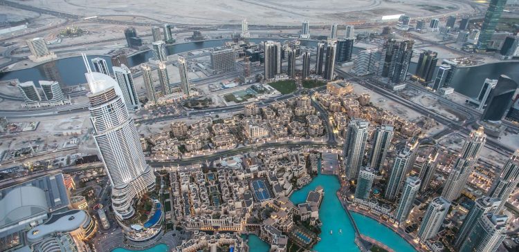 Panorama centrum Dubaju z lotu ptaka, gęsta zabudowa wieżowców, kanały wodne i nowoczesna infrastruktura miejska widziane o zmierzchu.