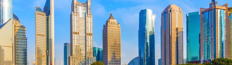 Panorama nowoczesnej dzielnicy biznesowej w Dubaju z parkiem i ulicą na pierwszym planie.