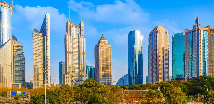 Panorama nowoczesnej dzielnicy biznesowej w Dubaju z parkiem i ulicą na pierwszym planie.