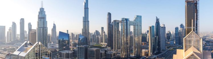 Panorama Dubaju z Burj Khalifa i siecią wielopoziomowych autostrad, otoczona nowoczesnymi drapaczami chmur w centrum miasta.