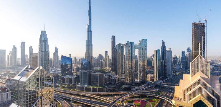 Panorama Dubaju z Burj Khalifa i siecią wielopoziomowych autostrad, otoczona nowoczesnymi drapaczami chmur w centrum miasta.