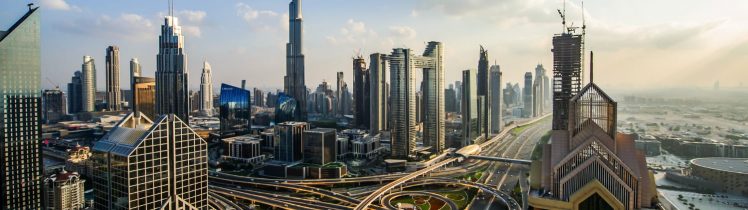 Panorama Dubaju z wieżowcem Burj Khalifa i wielopoziomowymi autostradami Sheikh Zayed Road otoczonymi nowoczesnymi drapaczami chmur.