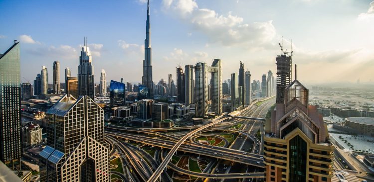 Panorama Dubaju z wieżowcem Burj Khalifa i wielopoziomowymi autostradami Sheikh Zayed Road otoczonymi nowoczesnymi drapaczami chmur.