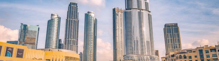 Panorama centrum Dubaju z nowoczesnymi wieżowcami Emaar i fontanną Dubai Fountain w słoneczny dzień