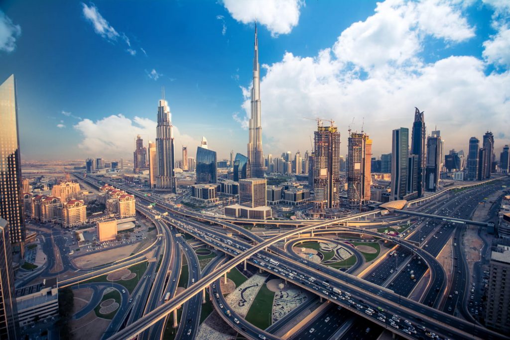 Panorama Dubaju z Burj Khalifa w centrum oraz rozbudowaną siecią autostrad i nowoczesnych wieżowców w słoneczny dzień