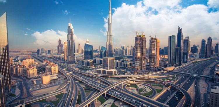 Panorama Dubaju z Burj Khalifa w centrum oraz rozbudowaną siecią autostrad i nowoczesnych wieżowców w słoneczny dzień