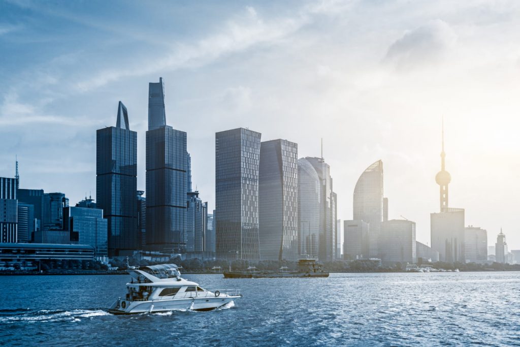 Nowoczesna panorama Szanghaju nad rzeką Huangpu z łodzią na wodzie i charakterystyczną wieżą Oriental Pearl w tle