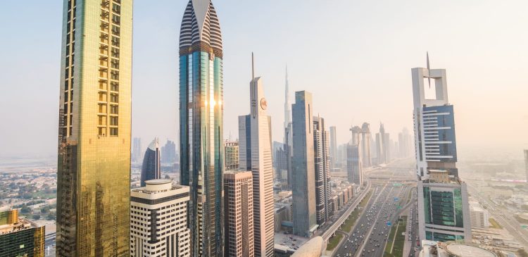 Panorama nowoczesnego centrum Dubaju z wieżowcami przy Sheikh Zayed Road i widokiem na Burj Khalifa o zachodzie słońca.