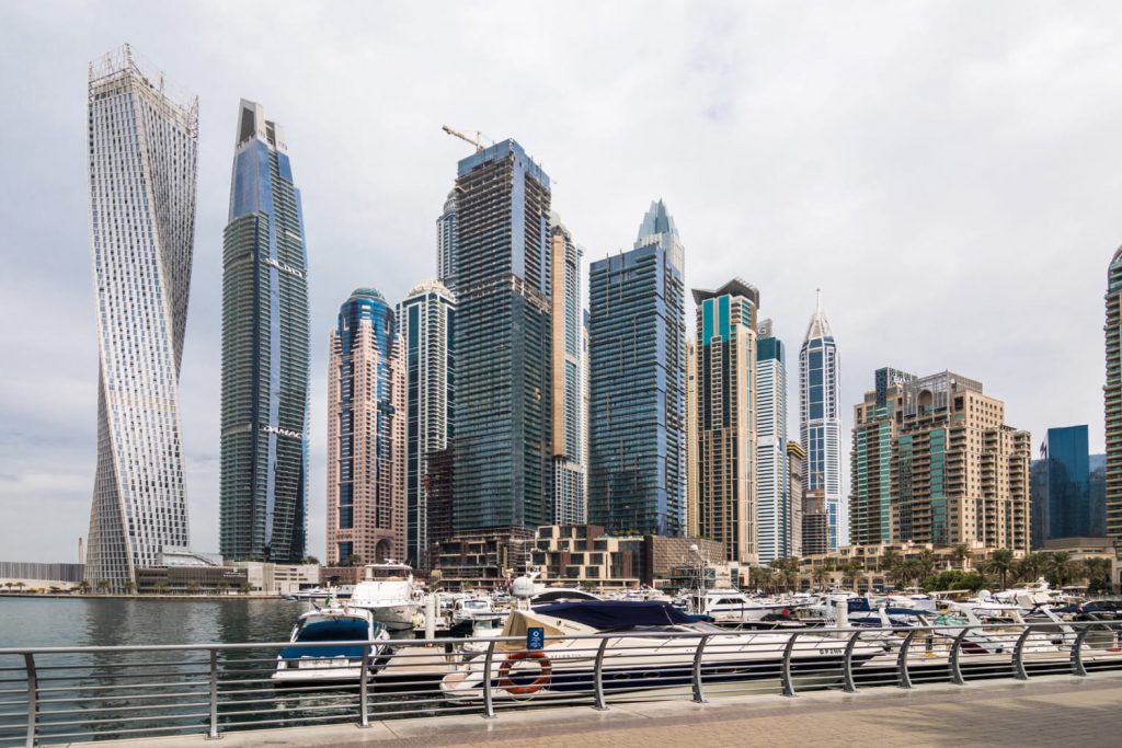 Nowoczesna panorama Dubai Marina z luksusowymi wieżowcami i mariną pełną jachtów nad wodą.
