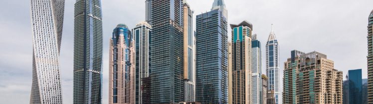 Nowoczesna panorama Dubai Marina z luksusowymi wieżowcami i mariną pełną jachtów nad wodą.
