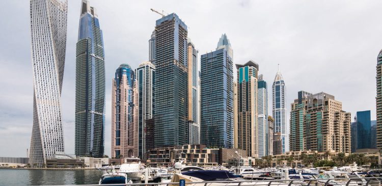 Nowoczesna panorama Dubai Marina z luksusowymi wieżowcami i mariną pełną jachtów nad wodą.