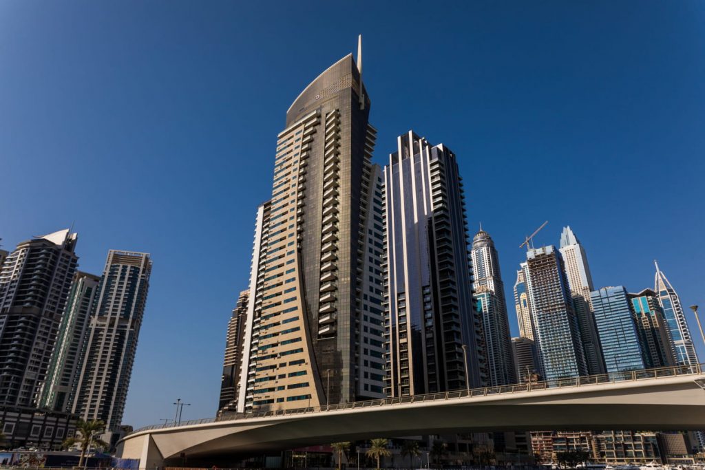 Nowoczesne wieżowce i apartamentowce w centrum Dubaju z widokiem na miejską infrastrukturę i bezchmurne niebo.
